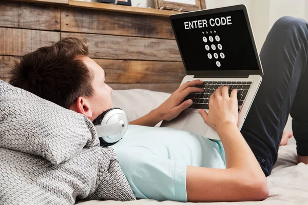 Homem inserindo código em um laptop para obter acesso a um sistema privado — Fotografia de Stock