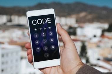 Giriş kodu ile hareket eden telefon içinde belgili tanımlık perde tutan adam. Anahtarcı telefon.
