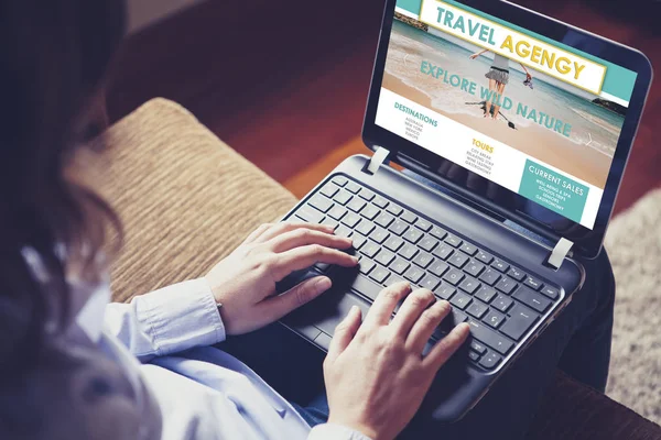 Mulher procurando destino em um site de agência de viagens com um computador portátil, sentado em casa . Imagens De Bancos De Imagens