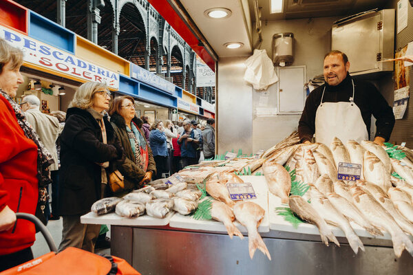 Malaga, Spain: 5th December, 2017: Fishmonger selling fresh fish in his shop at Atarazanas Market, in Malaga city center, Spain, on December 5th, 2017.