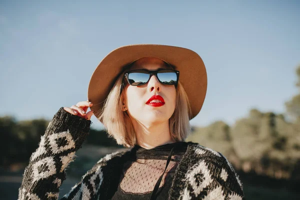 Niedliche weiße Frau mit Hut und Sonnenbrille genießt draußen und schaut in den blauen Himmel. — Stockfoto
