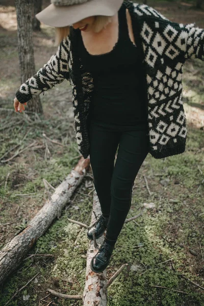 Frau in Freizeitkleidung spaziert auf umgestürztem Baumstamm im Wald — Stockfoto