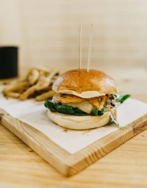 Bir barda ahşap masada hamburger ve patates kızartması.