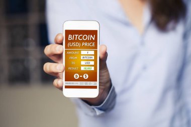 Bir cep telefonu ekran Bitcoin Usd fiyat bilgileri. Telefon elinde tutan kadın.