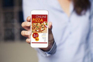Bir cep telefonu ekran app alışveriş satır pizzaya. Kadın el cihazı tutarak yakın çekim.