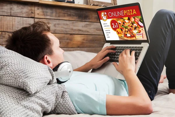 Man met een laptopcomputer te bestellen pizza via internet. — Stockfoto
