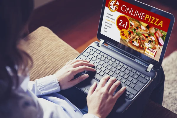 Internet tarafından bir pizza sipariş etmek için dizüstü bilgisayar kullanan kadın. — Stok fotoğraf