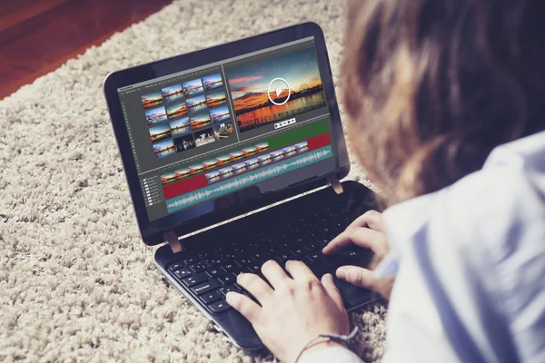 Женщина редактирует видео с ноутбуком дома . — стоковое фото