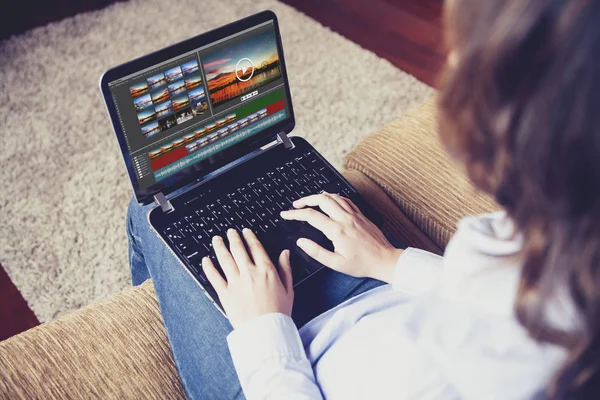 Mulher edição de vídeo com um laptop enquanto sentado em casa . — Fotografia de Stock