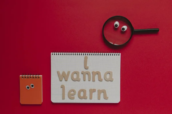 Zurück zum Schulkonzept, "i wanna learn" Schriftzug auf einem Notizbuch, mit animierten Sachen. roter Hintergrund. — Stockfoto