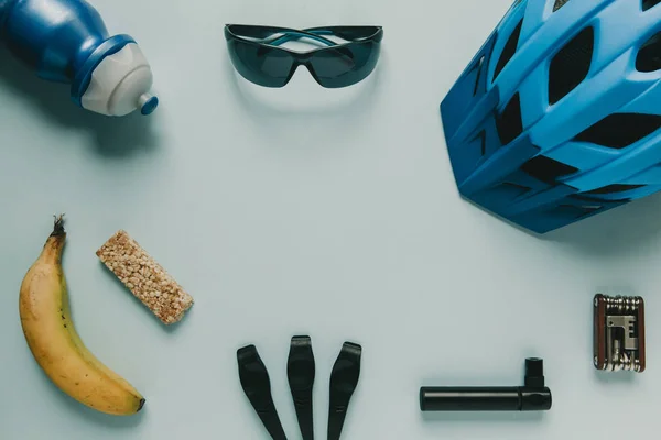 Accesorios de ciclismo y comida con espacio para copiar sobre fondo azul . — Foto de Stock