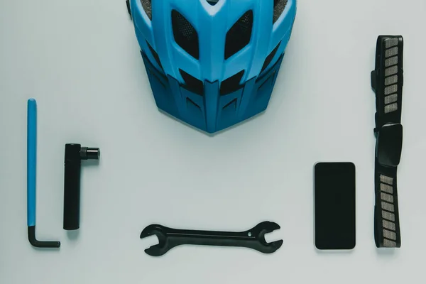 Fahrradausrüstung und Handy auf blauem Hintergrund. — Stockfoto