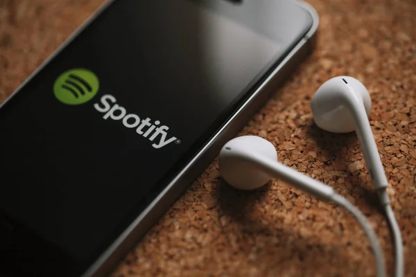 Spotify-Musikstreamingdienst auf Smartphone-Bildschirm und weißen Kopfhörern. — Stockbild Malaga, spanien - 5. märz 2018: handy mit spotify-logo auf dem bildschirm und weißen kopfhörern, platziert auf einer korkplatte. — Stockfoto
