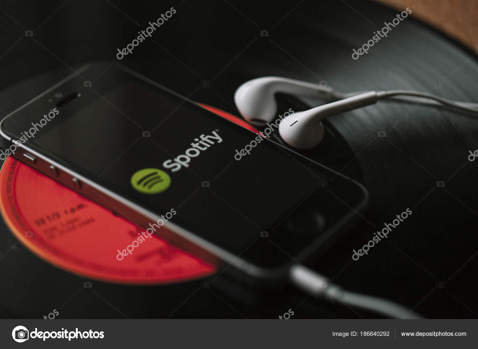 Herunterladen - Spotify-Musikstreamingdienst auf Smartphone-Bildschirm und weißen Kopfhörern. — Stockbild Malaga, spanien - 5. märz 2018: handy mit spotify-musik-service auf dem bildschirm und weißen kopfhörern auf schwarzer schallplatte. — Stockfoto