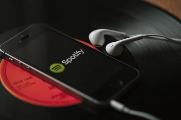 MALAGA, ESPAÑA - 5 DE MARZO DE 2018: Teléfono móvil con servicio Spotify Music en pantalla y auriculares blancos en un disco de vinilo negro . Imágenes De Stock Sin Royalties Gratis