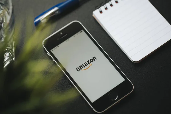 MALAGA, SPAGNA - 6 MARZO 2018: Cellulare con app Amazon su schermo bianco, su una scrivania nera con materiale per ufficio . — Foto Stock