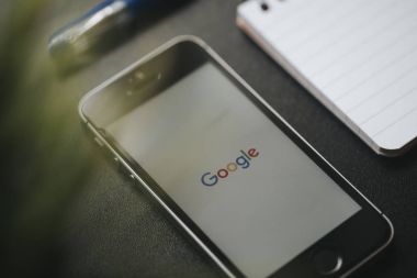 Malaga, İspanya - 6 Mart 2018: Makro ayrıntı Google App bir siyah çalışma alanı diğer office malzeme ile yerleştirilen bir cep telefonu ekranında,.