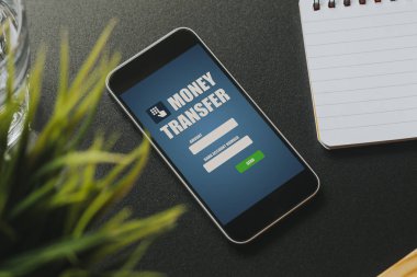 Bir cep telefonu ekran siyah iş tablo üzerinde para transferi uygulaması.