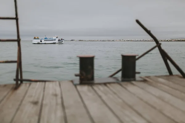 Île d'Armona, Portugal - 23 mars 2018 : jetée de l'île d'Armona avec ferry pour Olhao en arrière-plan par temps nuageux, au Portugal . — Photo