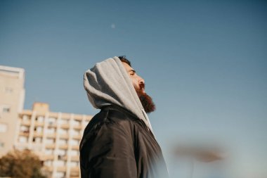 Genç adam öğe, dikey, güneşin kentsel sokak stil giysileri ile bir yüz yan sakallı