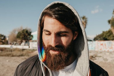 Genç adam öğe, dikey, güneşin yüzüne, kentsel sokak stil giyim sakallı.