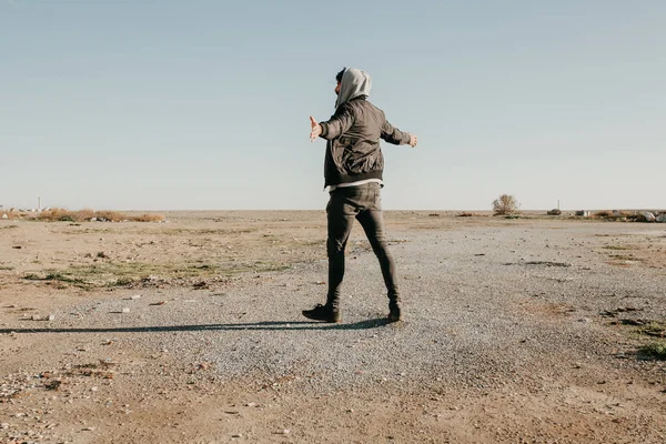 Giovane uomo che cammina all'aperto al tramonto con stile di vestiti rapper urbano . — Foto Stock