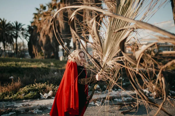 Cool jongedame spelen en kampen met palm boomtakken buitenshuis. — Stockfoto