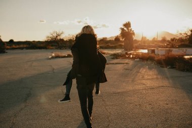 Serin indie çift onların arka açık havada o onu bir sırtlama üzerinde terk edilmiş bir yer, günbatımı güzel bir Altın ışık ile sırasında süre verir eğleniyor.