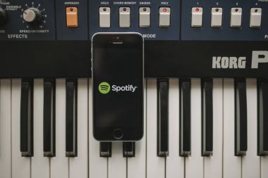 Malaga, İspanya - 12 Nisan th, 2018: Spotify akarsu müzik app iphone ekranında, yerleştirilen bir vintage müzikal klavye üzerinde.
