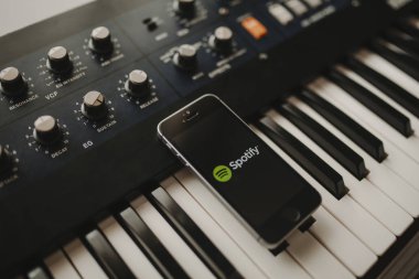 Malaga, İspanya - 12 Nisan th, 2018: Spotify akarsu müzik app iphone ekranında, yerleştirilen bir vintage müzikal klavye üzerinde.