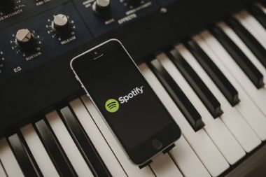 Malaga, İspanya - 12 Nisan th, 2018: Spotify akarsu müzik app iphone ekranında, yerleştirilen bir vintage müzikal klavye üzerinde.