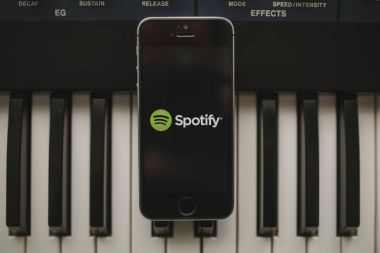 Malaga, İspanya - 12 Nisan th, 2018: Spotify akarsu müzik app iphone ekranında, yerleştirilen bir vintage müzikal klavye üzerinde.