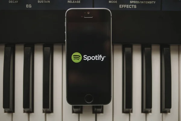 MALAGA, ESPAÑA - 12 DE ABRIL DE 2018: Spotify Streaming aplicación de música en una pantalla de iPhone, colocado en un teclado musical vintage . —  Fotos de Stock