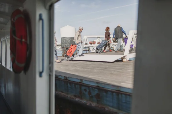 24 DE MARZO DE 2018 - OLHAO, PORTUGAL: Personas bajando de un barco y llegando a Olhao, en Portugal, después del viaje navegando por Ria Formosa desde la isla de Armona, el 24 de marzo de 2018 . — Foto de Stock