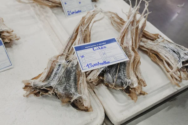 Pesci lisa essiccati al mercato del pesce con listino prezzi in lingua portoghese . — Foto Stock