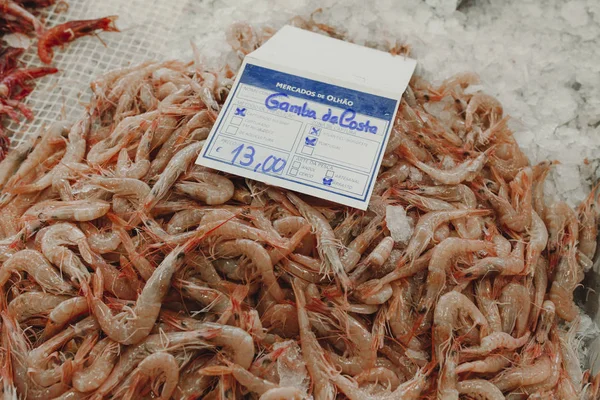 Ramo de camarones frescos crudos sobre hielo en un mercado portugués . —  Fotos de Stock