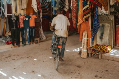 Rissani, Fas - 18 Eylül 2019: Fas 'taki Risanni Çarşısı' nda bisikletle koridordan geçen adam.
