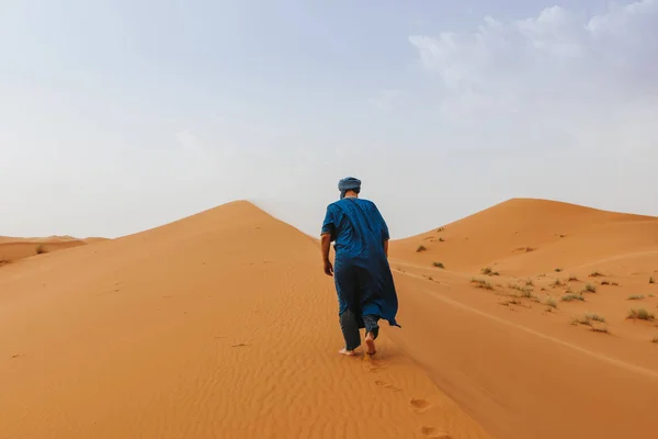 一个人走在沙漠沙丘上穿着经典的柏柏尔服装 — 图库照片