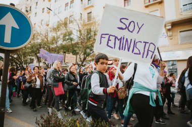 MALAGA, SPAIN - MARCH 8 th, 2020: Young child showing feminist banner during feminist strike in Malaga, Spain, on March 8 th, 2020.