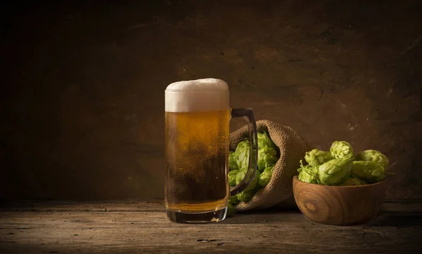 Beer keg with glasses of beer on rural countryside background