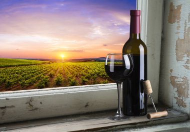 kırmızı şarap şişesi ve şarap kadehi yün fıçıda.