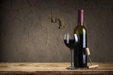 kırmızı şarap şişesi ve şarap kadehi yün fıçıda.