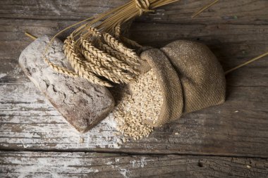 Ekmek kopya alan arka plan ağaç sınırında. Kahverengi ve beyaz tam tahıl somun natürmort kompozisyon buğday kulakları ile dağılmış. Ekmek pasta ve bakkal gıda mağaza konsepti.