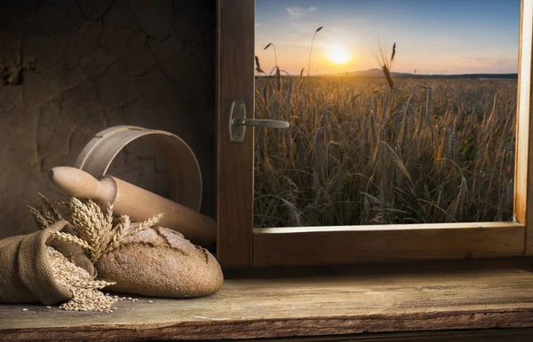 Pan fresco en la mesa de la cocina frente a una ventana con un panorama rural, comida saludable y concepto de panadería tradicional — Foto de Stock