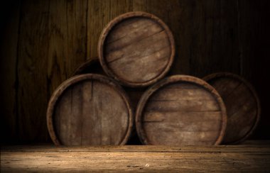 Old oak barrel on a wooden table. Behind blurred dark background. clipart