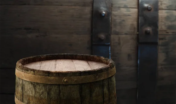 Old oak barrel on a wooden table. Behind blurred dark background.