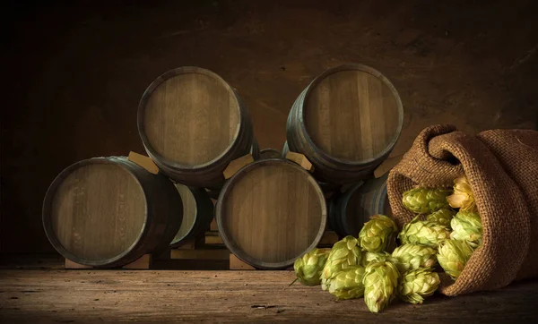 Blurred background of brown barrels and hop in basket — Stock Photo, Image