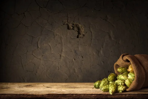 Verschwommener Hintergrund aus braunen Fässern und Hopfen im Korb — Stockfoto