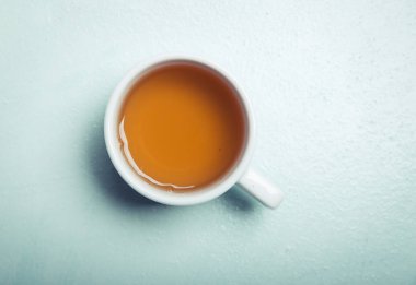 Gri ahşap zemin üzerine yeşil çay bardağı