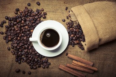 Bir fincan kahve, poşet ve eski paslı arka planda kepçe